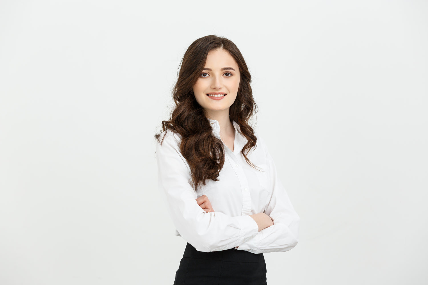 Confident young businesswoman in white shirt posing with arms crossed – representing leadership and trust behind the Enerosora brand mission
